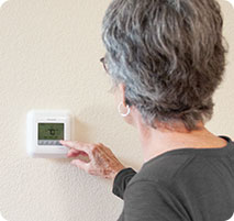 Prescott woman adjusting thermostat